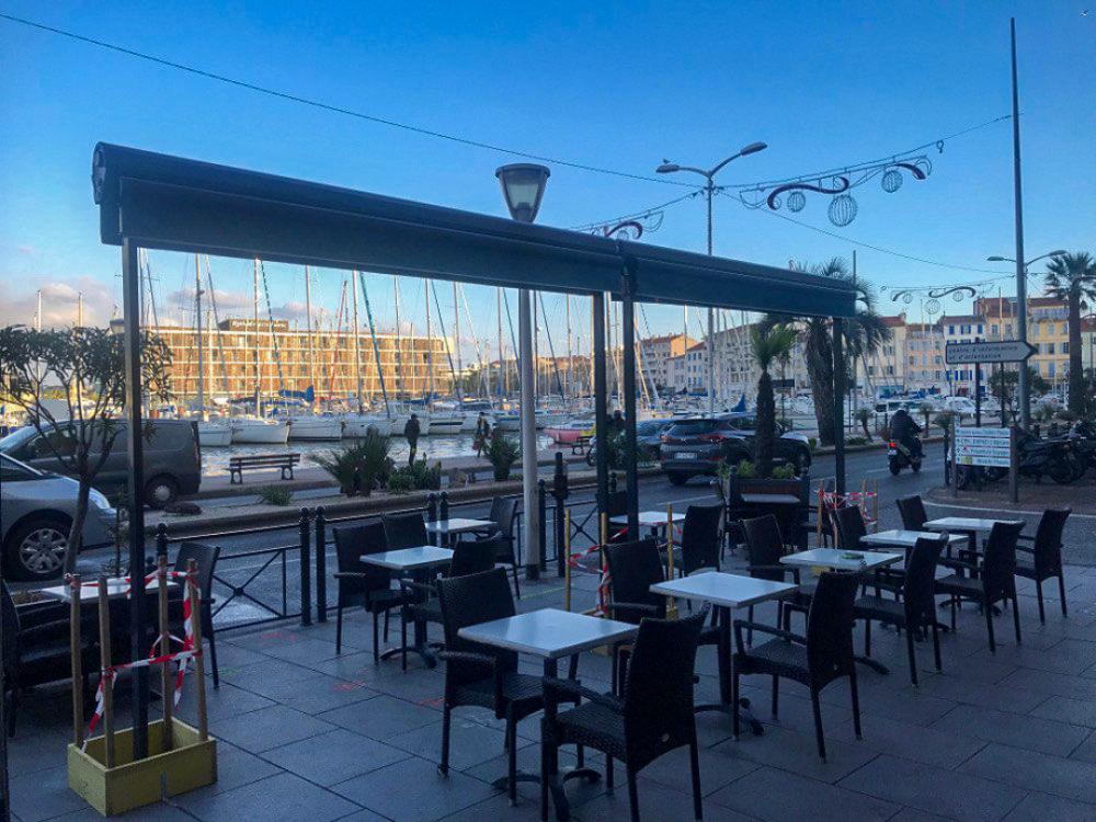 Stores double pente refermés sur une terrasse de café